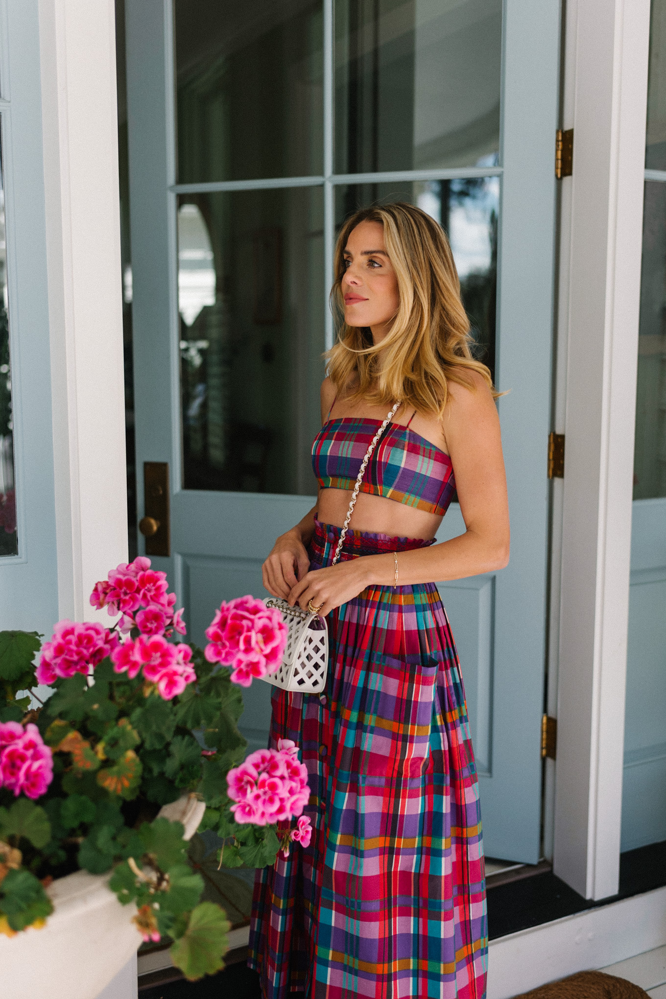 pink madras skirt and crop top set white woven bag